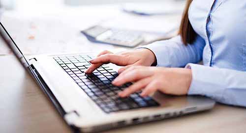 Internship Program Young woman typing on a laptop computer.