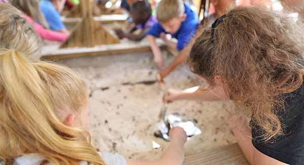 Children digging in dirt for educational activity