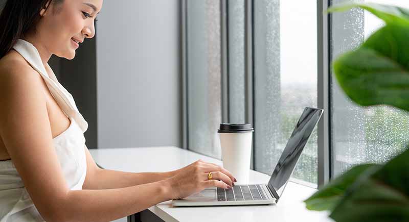 Woman typing on a laptop.