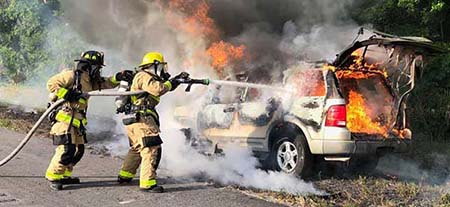Firefighters spraying car fire Firefighters spraying car fire