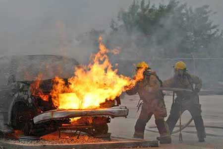 Firefighters putting out car fire Firefighters putting out car fire