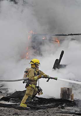 Firefighter spraying firehose
