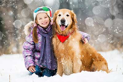 Little girl and her dog in the snow.
