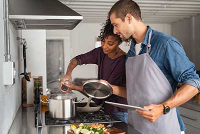 2 people cooking dinner.