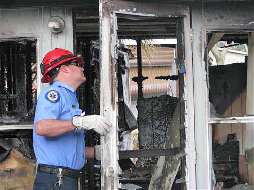 IMG_3279 Fireman inspecting a door in a burned down house.