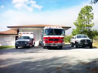 A fire truck, emergency vehicle and ambulance in front of Station 26