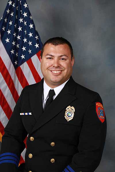 Ocean Rescue Chief Eisen Witcher with an American flag in the background.