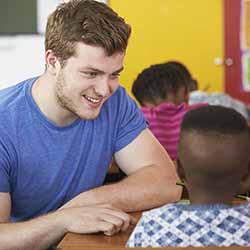 Young man teaching a child.