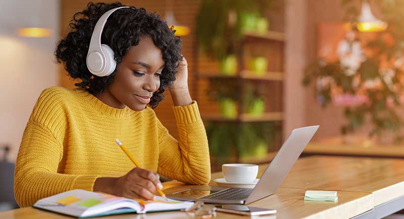 Woman With Headphones On Laptop