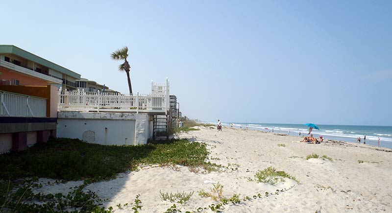 The shoreline is 100+ yards away from the side of a condo. The condo now resides on a dune with hundreds of feet of beach between it and the shoreline.