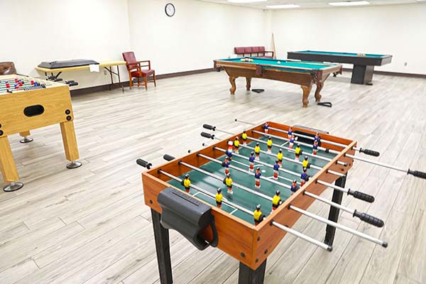 Foosball and pool tables in game room
