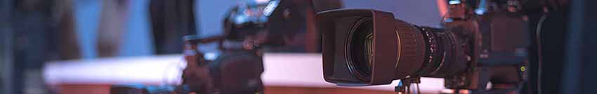 camera Video camera in the forefront of a studio environment.